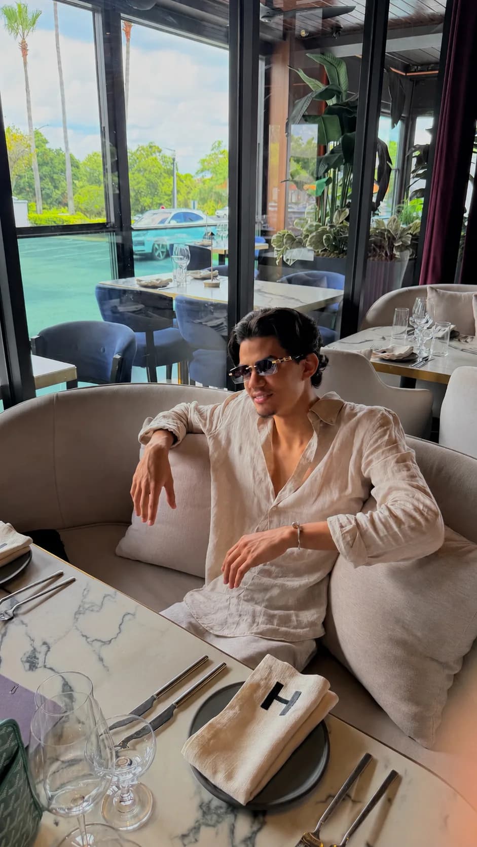 Lucas sentado em um restaurante sofisticado
